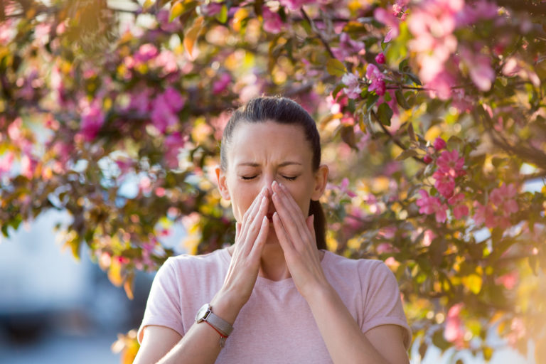 mujer con alergia respiratoria en el campo