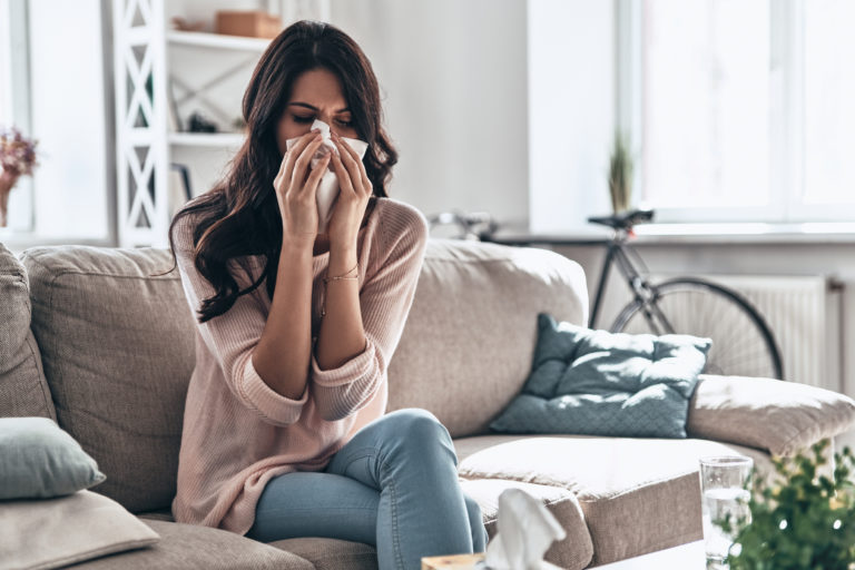 ¿Alergia o COVID-19? Mujer resfriada sentada en el sofá